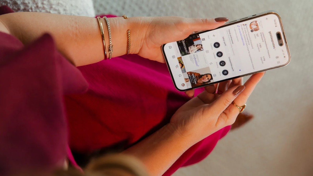 Mão segurando um celular que exibe um relatório